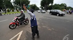  Petugas saat memberikan petunjuk kepada pengendara roda dua untuk tidak melintasi Jl Merdeka Barat untuk memasuki kawasan Monas,  Jakarta, Kamis (1/1/2015). ( Liputan6.com/Miftahul Hayat)