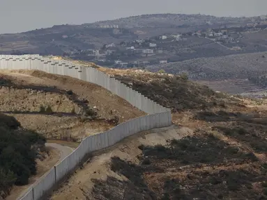 Sebuah foto yang diambil dari Israel memperlihatkan perbatasan yang memisahkan Israel utara dari Lebanon selatan, dengan desa Lebanon Ain Ebel terlihat di latar belakang pada 16 November 2025. Israel membangun tembok perbatasan baru di sepanjang garis perbatasan dengan Lebanon wilayah bagian Selatan. (Jalaa MAREY/AFP)