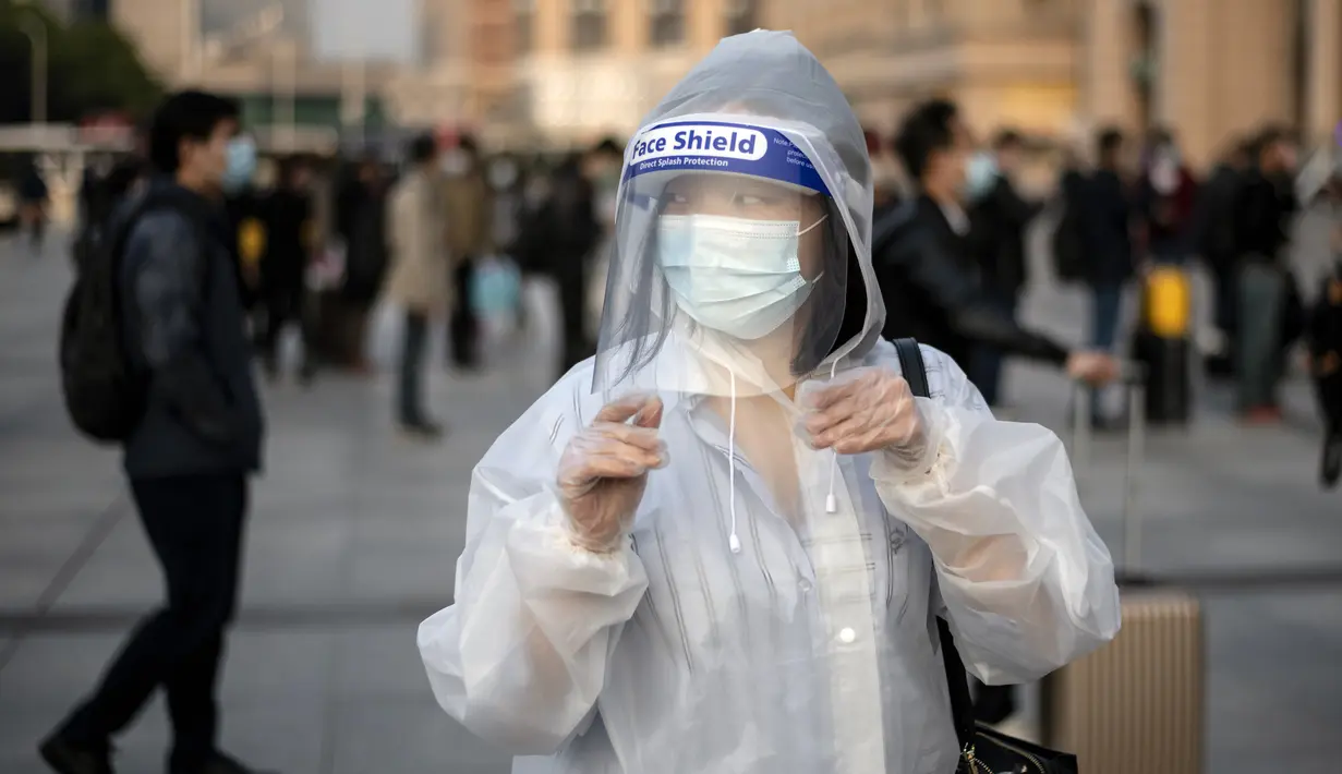 Penampilan warga saat tiba di Stasiun Hankou, Wuhan, Hubei, China, Rabu (8/4/2020). Setelah pandemi virus corona COVID-19 mereda, banyak warga di Wuhan beraktivitas memakai masker, sarung tangan, pelindung wajah, hingga pakaian pelindung. (NOEL CELIS/AFP)