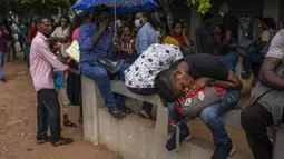 Seorang pria tidur siang saat bersama dengan yang lain menunggu dalam antrean untuk mendapatkan paspor mereka di luar Departemen Imigrasi &amp; Emigrasi di Kolombo, Sri Lanka, Senin (18/7/2022). Negara kepulauan Samudra Hindia itu dilanda krisis ekonomi yang belum pernah terjadi sebelumnya yang telah memicu ketidakpastian politik. (AP Photo/Rafiq Maqbool)