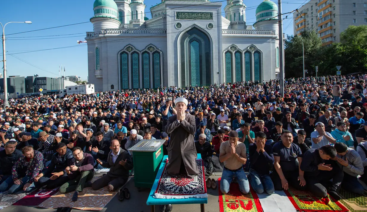 Umat muslim memanjatkan doa saat melaksanakan salat Idul Fitri di luar Masjid Katedral Moskow, Moskow, Rusia, Selasa (4/6/2019). Selain Rusia, sejumlah negara juga merayakan Hari Raya Idul Fitri hari ini. (AP Photo/Alexander Zemlianichenko)