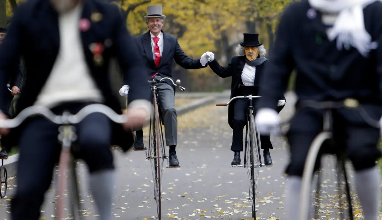 Peserta mengendarai sepeda penny farthing lengkap dengan mengenakan kostum yang berbau sejarah saat mengikuti balapan Penny Farthing tahunan di Praha, Republik Ceko (5/11). (Reuters/David W Cerny)