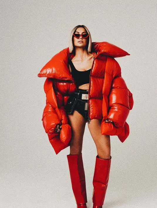 Gaya nyentrik ala seleb Hollywood dari Agnez Mo. Ia mengenakan puffer jacket merah super besar, dipadu dengan high boots yang juga berwarna merah. Agnez Mo memadukannya dengan innerwear hitam dan short pants denim. Foto: Instagram.