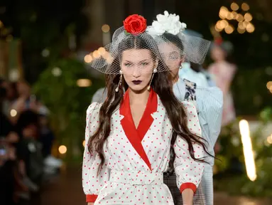 Bella Hadid berjalan di catwalk untuk show Rodarte pada New York Fashion Week: The Shows di New York City, Selasa (11/2/2020). Bella Hadid seolah-olah kembali ke era tahun 50an dalam balutan gaun polkadot merah dan putih dengan kerudung yang menutupi wajahnya. (FERNANDA CALFAT/GETTY IMAGES/AFP)