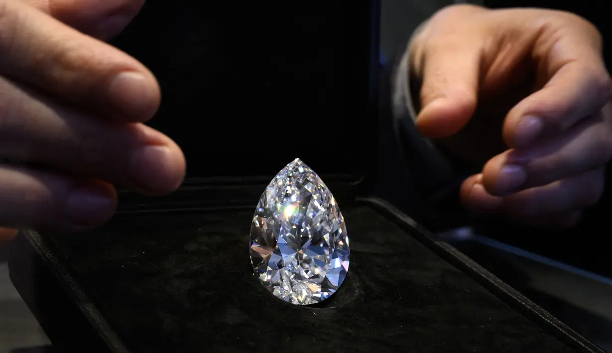 <p>'The Rock', berlian putih berbentuk buah pir 228,31 karat (perkiraan: USD 20.000.000-30.000.000) yang ditambang dan dipoles di Afrika Selatan lebih dari dua dekade lalu ditampilkan oleh Rumah Lelang Christie di Jenewa, Swiss, 6 Mei 2022. 'The Rock' akan ditawarkan pada 11 Mei 2022 saat penjualan "Permata Luar Biasa Christie". (Fabrice COFFRINI/AFP)</p>