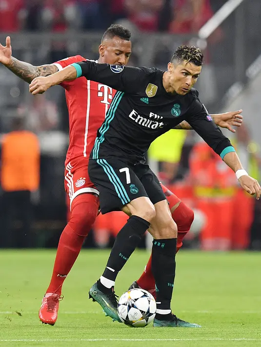 Pemain Bayern Munchen, Jerome Boating berebut bola dengan megabintang Real Madrid, Cristiano Ronaldo pada leg pertama semifinal Liga Champions di Allianz Arena, Rabu (25/4). Real Madrid berhasil menumbangkan Bayern Munchen 2-1. (AP/Kerstin Joensson)