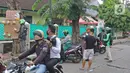 Pengemudi ojol mengambil paket bahan makanan yang digantung seniman wayang uwuh, Iskandar Hardjodimuljo di jalan Cawang Baru Utara, Jakarta, Sabtu (18/4/2020). Paket yang bernama "Wayang Bersedekah" itu untuk membantu warga yang kesulitan akibat dampak pandemi covid-19 (Liputan6.com/Herman Zakharia)