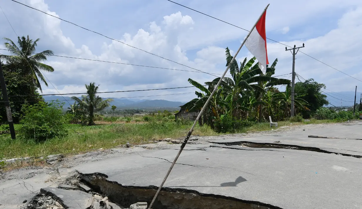 Jalanan rusak usai gempa dan tsunami melanda Kabupaten Sigi, Sulawesi Tengah, Kamis (4/10). Menurut data Badan Nasional Penanggulangan Bencana (BNPB), sebanyak 64 orang meninggal dunia akibat gempa dan tsunami di Sigi. (ADEK BERRY/AFP)