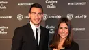 Bek Manchester United, Matteo Darmian menggandeng istrinya, Francessca Darmian di karpet merah makan malam acara amal UNICEF di Old Trafford, Rabu (15/11). Event ini sekaligus ajang pamer istri dan kekasih (WAGs) pasukan Red Devils. (Paul ELLIS/AFP)