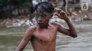 Seorang anak bermain di Sungai Ciliwung, Jakarta, Selasa (24/8/2021). Sungai Ciliwung menjadi tempat alternatif untuk bermain di kala pandemi karena ditutupnya ruang-ruang bermain atau taman kota, dan juga karena kurangnya ruang bermain bagi anak-anak. (Liputan6.com/Johan Tallo)