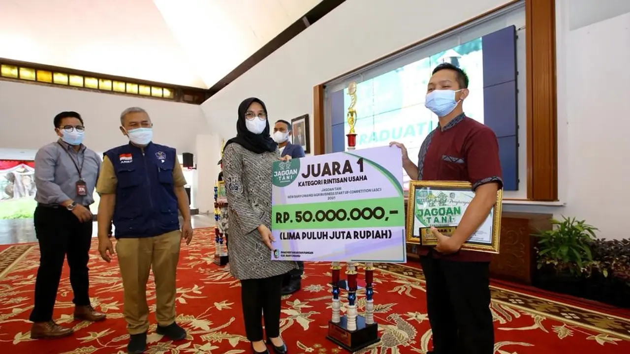 Bupati Banyuwangi Ipuk Fiestiandani menyerahkan hadian pada pemenang jagoan tani pada 2021. (Istimewa)