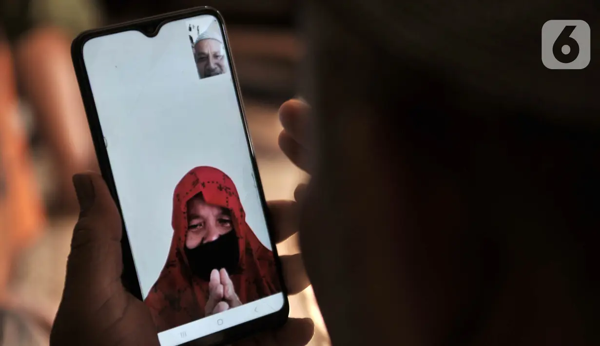 Warga bermaaf-maafan dengan keluarga melalui panggilan video saat halalbihalal Idul Fitri di Jakarta, Minggu (24/5/2020). Halalbihalal virtual menjadi alternatif bersilaturahmi dengan keluarga di kampung halaman akibat tidak dapat mudik karena wabah virus COVID-19. (merdeka.com/Iqbal S. Nugroho)