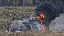 Seorang pilot yang selamat dari kecelakaan berjalan menjauh dari helikopter Mi-28N di Dubrovichi, Rusia, Minggu (2/8/2015). Helikopter  tersebut jatuh saat pertunjukan udara dan menewaskan satu dari dua orang pilot. (REUTERS/Maxim Shemetov)