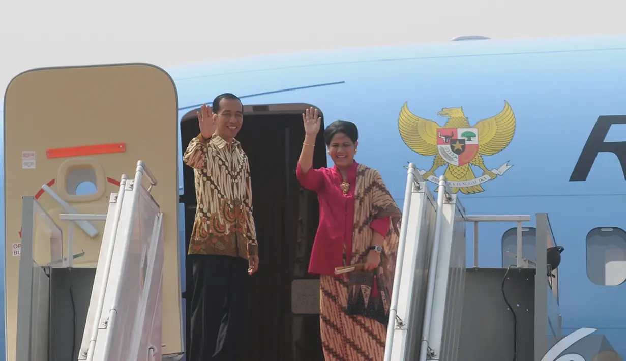 Jokowi dan Iriana melambaikan tangan saat akan bertolak ke Tiongkok di Bandara Halim Perdanakusuma, Jakarta, Sabtu (9/11/2014) (Liputan6.com/Herman Zakharia) 