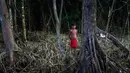Seorang anak Waiapi berdiri di hutan sambil mencari kayu bakar di desa Manilha di negara bagian Amapa, Brasil (14/10). Waiapi tinggal di sebuah cagar alam yang merupakan bagian dari zona konservasi besar, yang disebut Renca. (AFP Photo/Apu Gomes)