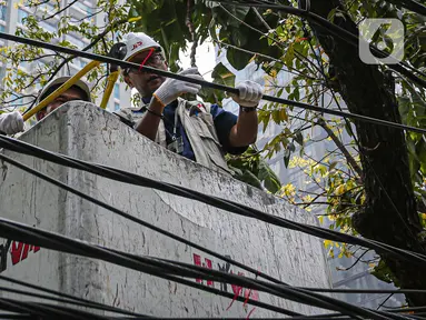 Petugas dari Dinas Bina Marga didampingi JIP memotong kabel fiber optik yang semrawut di kawasan Jalan Senopati, Jakarta, Kamis (24/8/2023). (Liputan6.com/Faizal Fanani)