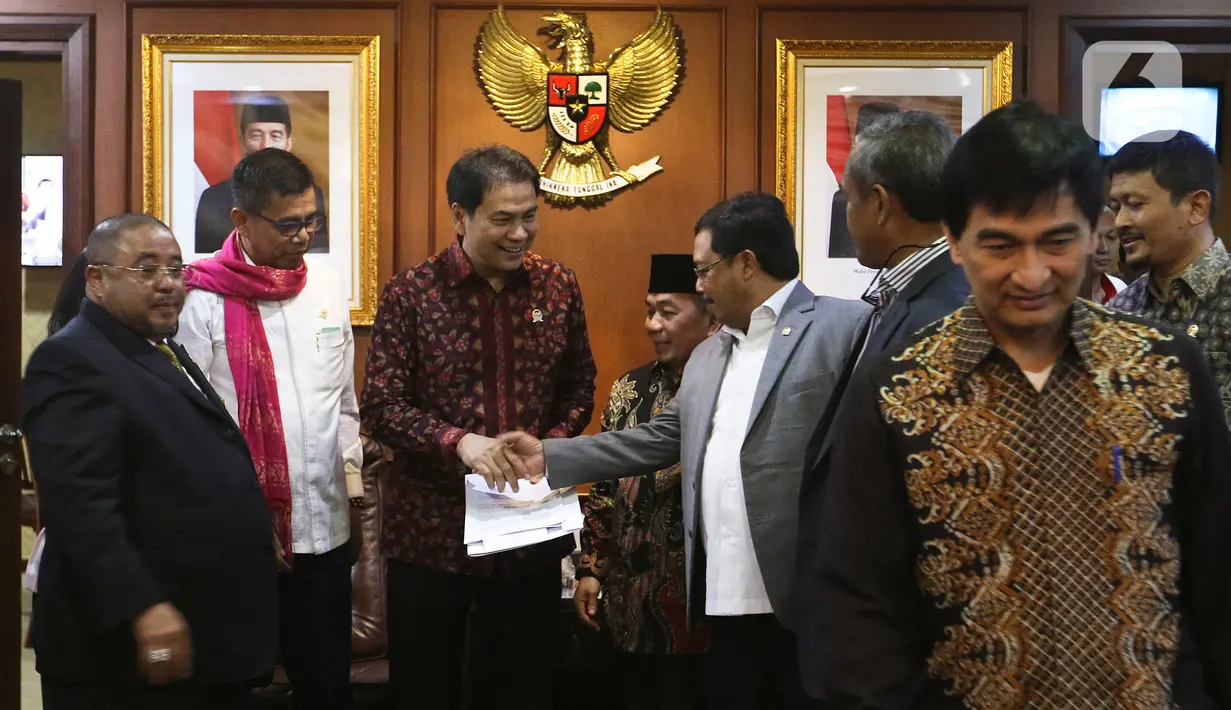 Fraksi Partai Keadilan Sejahtera (PKS) dan Fraksi Partai Demokrat memberikan berkas yang telah ditanda tangani anggota fraksi kepada Wakil Ketua DPR Azis Syamsudin (tengah) di Kompleks Parlemen, Jakarta, Selasa (4/2/2020). Berkas berisi usulan pembentukan Pansus Jiwasraya. (Liputan6.com/Johan Tallo)