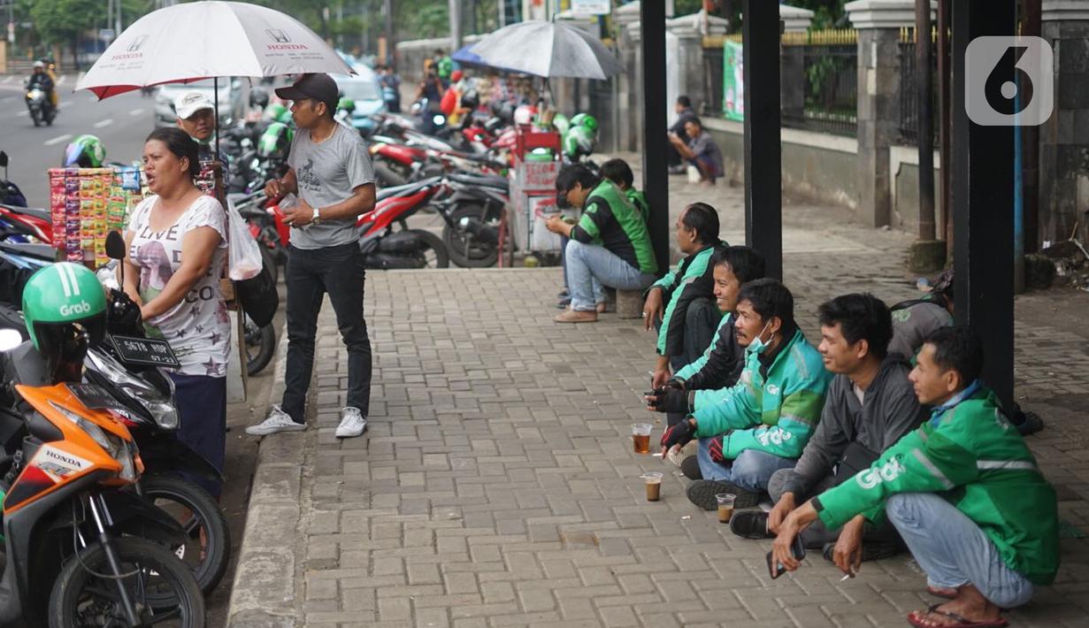 Aktivitas pengemudi ojek daring di depan Cibubur Junction, Jakarta, Selasa (24/3/2020). Merebaknya Covid-19 menyebabkan aktivitas di kawasan itu lesu yang juga berimbas pada turunnya pendapatan pengemudi ojek online hingga lima kali lipat dibanding hari biasanya. (Liputan6.com/Immanuel Antonius)