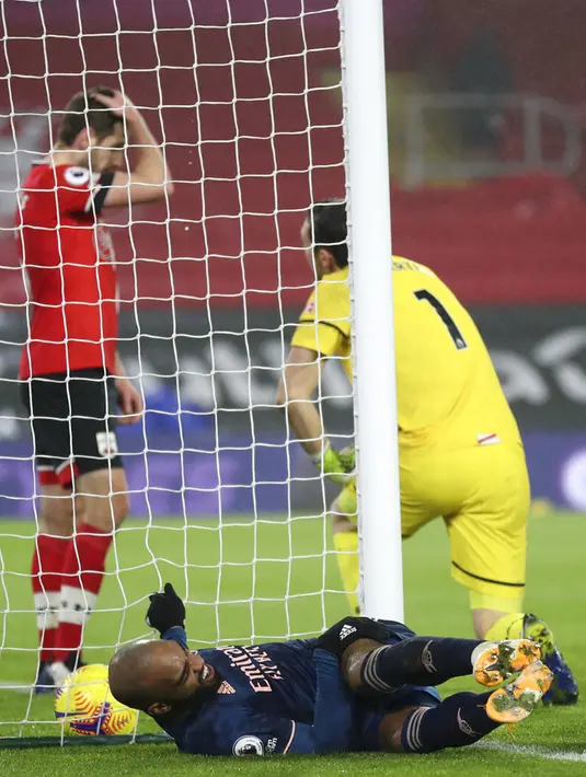 Pemain Arsenal Alexandre Lacazette (bawah) bereaksi setelah mencetak gol ke gawang Southampton pada pertandingan Liga Inggris di Stadion St Mary, Southampton, Inggris, Selasa (26/1/2021). Arsenal menang 3-1 atas Southampton. (Naomi Baker/Pool via AP)