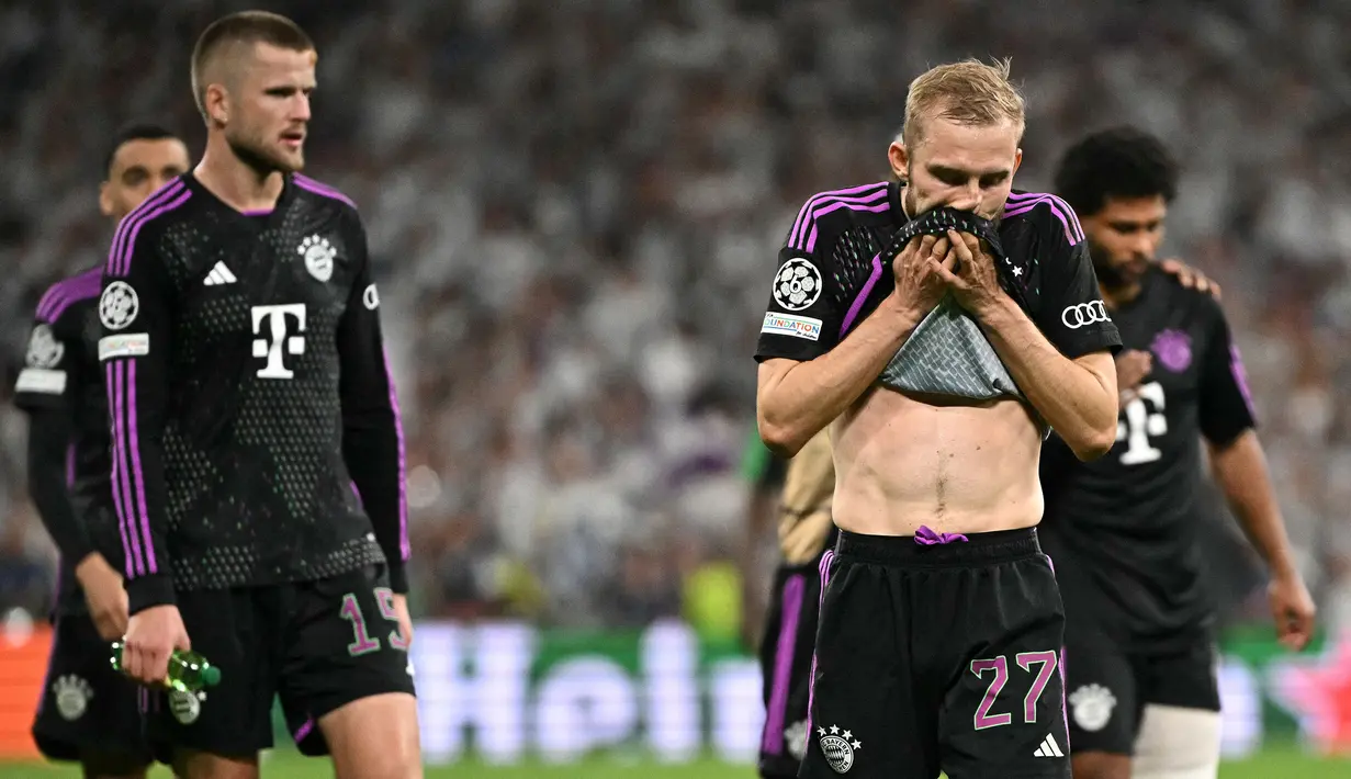 Pemain Bayern Munchen, Konrad Laimer (kedua kanan) menyeka wajahnya saat meluapkan rasa kecewa setelah kalah dari Real Madrid pada laga leg kedua semifinal Liga Champions 2023/2024 di Santiago Bernabeu, Madrid, Spanyol, Kamis (09/05/2024) WIB. (AFP/Javier Soriano)
