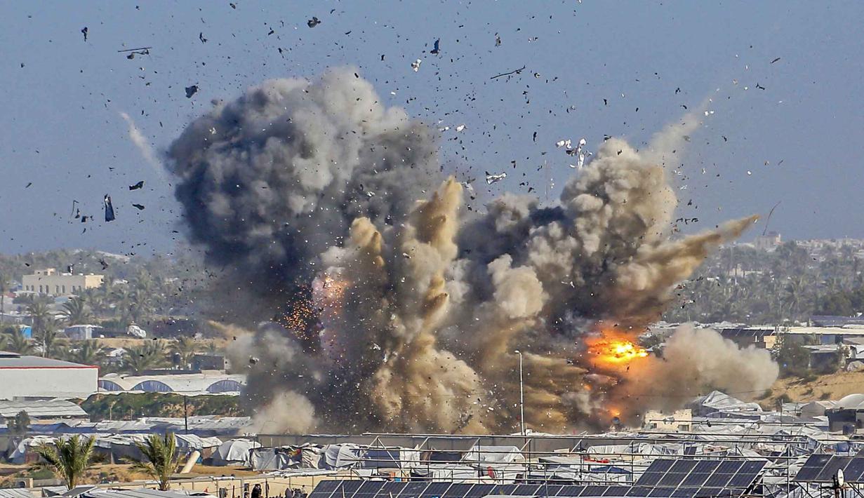 Asap dan api membubung dari tempat penampungan Gath, yang menampung pengungsi Palestina, setelah serangan udara Israel di sebelah barat Khan Yunis, Jalur Gaza selatan pada 31 Januari 2026. Serangan udara Israel kembali menghantam apartemen tempat tinggal warga, tenda pengungsian, serta sebuah kantor polisi di wilayah Gaza. (Bashar Taleb/AFP)