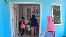 Ibu dan anaknya mengambil makan bergizi gratis (MBG) untuk dikonsumsi di rumah di Posyandu kawasan Limo, Depok, Jawa Barat, Selasa (14/7/2025).