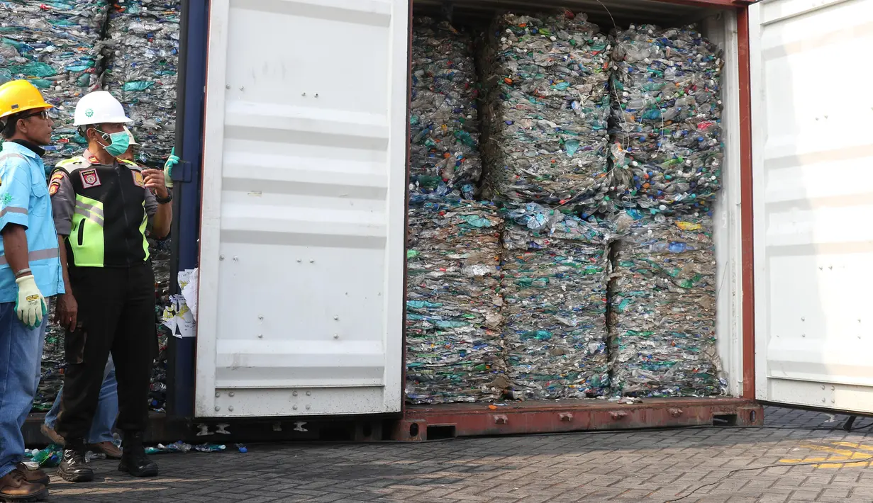 Polisi dan petugas tenaga kerja bongkar muat (TKBM) menunjukkan kontainer berisi sampah plastik di Tanjung Priok, Jakarta, Rabu (18/9/2019). Sampah plastik bercampur limbah B3 asal Australia tersebut merupakan hasil penindakan terhadap PT HI, PT NHI, dan PT ART. (Liputan6.com/Angga Yuniar)