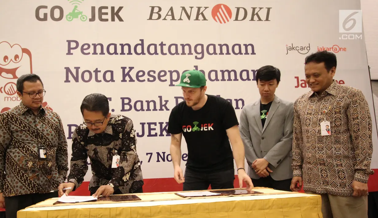 Direktur Bisnis Bank DKI,  Antonius Widodo Mulyono (kedua kiri) dan CMO Go-Jek,  Piotr Jakubowski (tengah) saat MoU antara Bank DKI dengan Gojek Indonesia, Selasa (7/11). (Liputan6.com/Pool/Budi)
