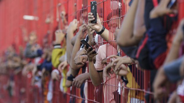 Suporter Persija Jakarta, The Jakmania, mengabadikan foto saat latihan perdana Macan Kemayoran di Lapangan Aldiron. (Bola.com/M. Iqbal Ichsan)