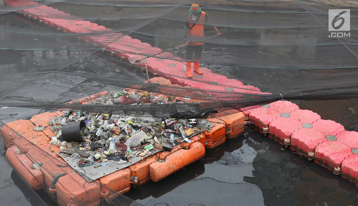 Petugas membersihkan Kali Item yang tertutup kain waring atau jaring di Kemayoran, Jakarta, Minggu (4/11). Sampah plastik, botol mineral, kaleng dan bungkus rokok bertebaran di waring yang membentang di atas Kali Item. (Liputan6.com/Immanuel Antonius)