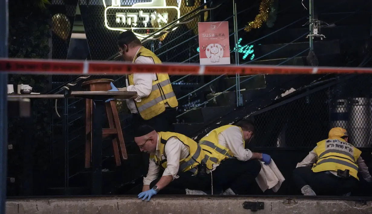 Anggota tim penyelamatan dan pemulihan Zaka membersihkan darah dari lokasi penembakan di Tel Aviv, Israel, 7 April 2022. Penembakan ini menjadi serangan keempat dalam beberapa pekan terakhir. (AP Photo/Ariel Schalit)