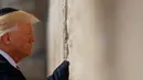 Presiden AS Donald Trump berdoa di Tembok Ratapan, tempat suci milik kaum Yahudi, di Yerusalem, Senin (22/5). Trump yang menganut Kristen Protestan, adalah presiden AS pertama yang mempunyai anggota keluarga inti orang Yahudi. (AP Photo/Evan Vucci)