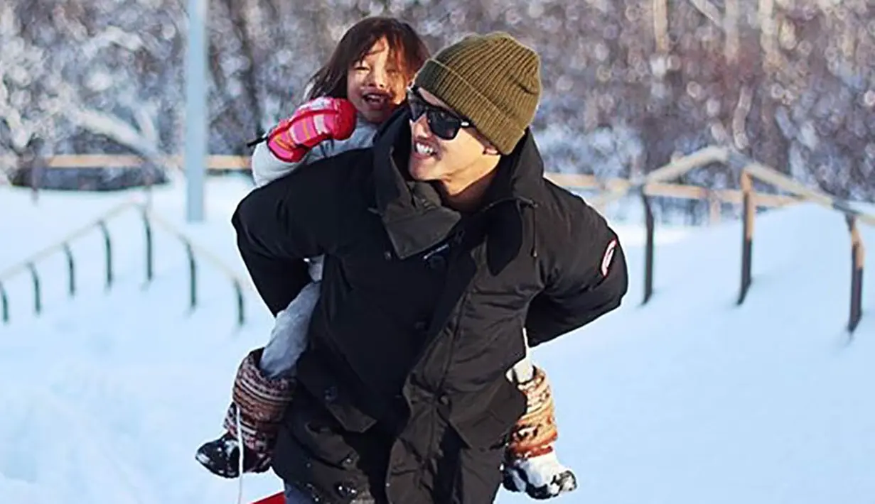 Pemain Consadole Sapporo, Irfan Bachdim menggendong putrinya saat bermain salju di Jepang. (Instagram)