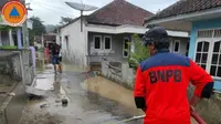 Seorang petugas BPBD Kuningan tengah memberishkan area Desa Kananga, Kabupaten Kuningan, Jawa Barat, yang terdampak peristiwa banjir. (Liputan6.com/ Dok BPBD Kuningan)