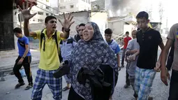Beberapa warga melarikan diri pasca serangan udara militer Israel menghantam sebuah pasar di Shejaia, sebelah timur kota Gaza, (30/7/2014). (REUTERS/Finbarr O'Reilly)