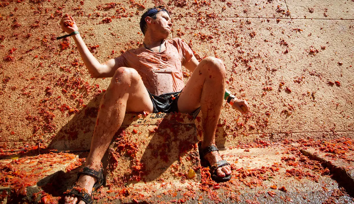Peserta melemparkan saat berpartisipasi dalam festival tahunan "Tomatina" di Bunol, salah satu kota di timur Spanyol, Rabu (29/8/2019). Perang tomat yang penuh kehebohan itu rutin diadakan setiap Rabu terakhir bulan Agustus. (JAIME REINA / AFP)