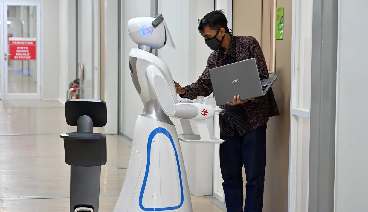 Teknisi mengecek robot Amy (tengah) dan Temi (kiri) saat simulasi membantu petugas medis dalam menangani pasien virus corona COVID-19 di Rumah Sakit Pertamina Jaya (RSPJ), Jakarta, Kamis (16/4/2020). RSPJ mengerahkan dua robot untuk membantu petugas medis menangani COVID-19. (ADEK BERRY/AFP)