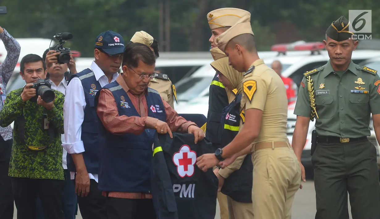 Ketua Umum PMI Jusuf Kalla memberi rompi kepada relawan PMI yang bertugas untuk Lebaran Tahun 2018  di lapangan stasiun Gambir,Jakarta, Kamis (7/6). Sebanyak 8.422 relawan dan para medis PMI di turunkan untuk lebaran tahun 2018.  (Merdeka.com/Imam Buhori)