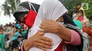 Seorang anak memeluk ibunya di Kelurahan Duri Pulo, Jakarta, Rabu (21/12/2021). Aksi mencuci kaki ibu secara massal yang diikuti 500 peserta itu bertujuan untuk meningkatkan rasa cinta kasih kepada ibu dan dilakukan dalam rangka memeriahkan Hari Ibu. (Liputan6.com/Herman Zakharia)