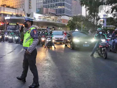 Petugas kepolisian melakukan giat buka tutup arus lalu lintas di kawasan Bundaran Hotel Indonesia, Jakarta, Senin (4/9/2023). (Liputan6.com/Angga Yuniar)