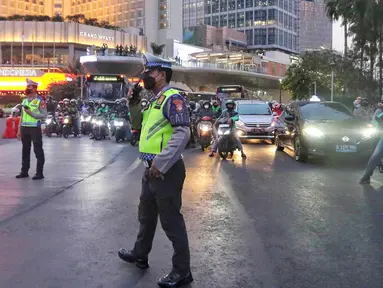 Petugas kepolisian melakukan giat buka tutup arus lalu lintas di kawasan Bundaran Hotel Indonesia, Jakarta, Senin (4/9/2023). (Liputan6.com/Angga Yuniar)