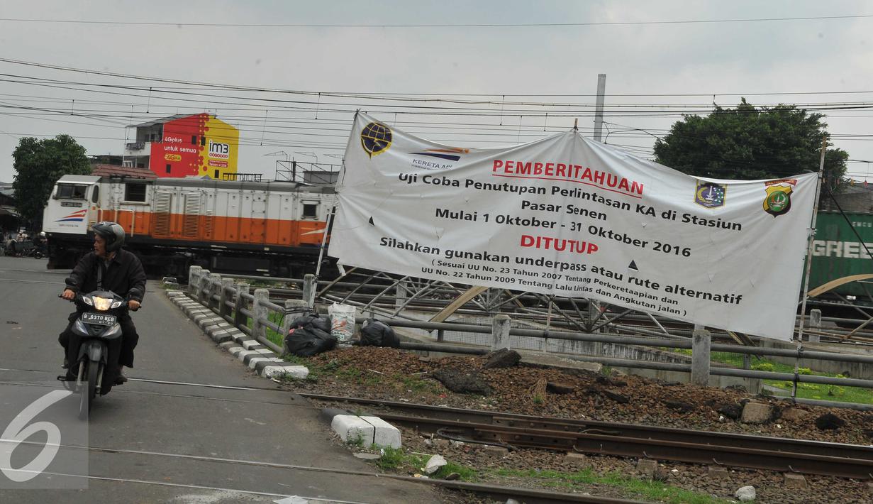 Pengendara motor melintasi spanduk sosialisasi penutupan perlintasan kereta sebidang di Stasiun Pasar Senen, Jakarta, (16/9). Uji coba penutupan perlintasan itu akan berlangsung selama satu bulan pada 1-31 Oktober 2016. (Liputan6.com/Gempur M Surya)