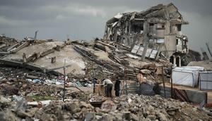 UNRWA menegaskan situasi ini dapat dicegah jika bantuan kemanusiaan tidak terhalang, termasuk dukungan medis dan tempat tinggal layak. Tampak dalam foto, warga Palestina berjalan melewati reruntuhan di tengah cuaca tengah cuaca buruk Kota Gaza, Kamis 11 Desember 2025. (AP Photo/Jehad Alshrafi)
