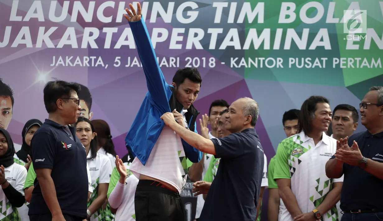 Direktur Pemasaran Pertamina Muchamad Iskandar (kedua kanan) mengenakan jaket kepada kapten tim putra Agung Seganti (tengah) saat Launching Tim Bola Voli Jakarta Pertamina Energi di Kantor Pusat Pertamina, Jakarta, Jumat (5/1).(Liputan6.com/Arya Manggala)