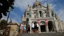 Wisatawan berjalan-jalan di basilika Sacre Coeur di distrik Montmartre, Paris pada Senin (10/8/2020). Penggunaan masker mulai hari Senin (10/8) diwajibkan di area luar ruangan yang ramai di ibu kota Prancis itu untuk mengendalikan peningkatan tingkat infeksi virus corona. (AP Photo/Michel Euler)