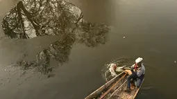 Tukang perahu menggunakan dayung memecahkan lapisan es di sepanjang bagian dalam Danau Dal pada pagi saat musim dingin di Srinagar (2/1/2023). Pada hari Senin Srinagar mencatat -5,4°C, Pahalgam -9,6°C dan Gulmarg -10°C sebagai suhu minimum. (AFP/Tauseef Mustafa)