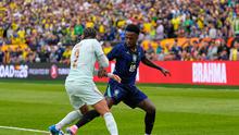 Malo Gusto dan Vinicius Junior berebut bola dalam laga uji coba internasional antara Brasil vs Prancis di Gillette Stadium, Massachusetts, 27 Maret 2026. (AP Photo/Charles Krupa)