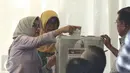 Istri Wapres Jusuf Kalla (JK), Mufidah Kalla, memasukkan surat suara usai mencoblos di TPS 03 Kelurahan Pulo, Jakarta Selatan, Rabu (19/4). Di TPS bernuansa Betawi itu, JK dan istri memberikan suaranya pada Pilkada DKI 2017. (Liputan6.com/Herman Zakharia)