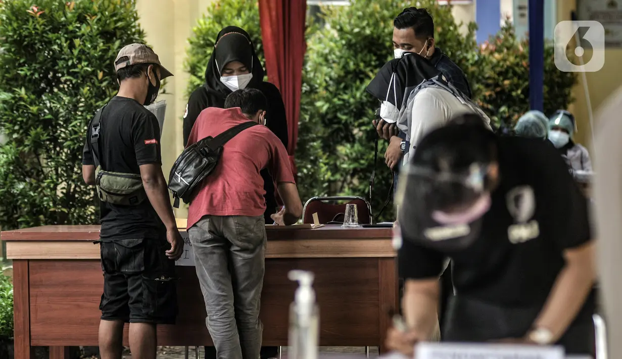 Keluarga korban Sriwijaya Air SJ 182 menjalani pendataan untuk tes usap COVID-19 sebelum memberikan data di Posko Ante Mortem DVI, RS Polri, Jakarta, Minggu (10/1/2020). Data keluarga korban diperlukan tim forensik RS Polri guna kepentingan identifikasi. (merdeka.com/Iqbal S. Nugroho)