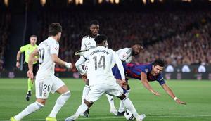 Pemain Barcelona, Ferran Torres terjatuh saat berebut bola dengan gelandang Real Madrid, Aurélien Tchouameni dalam pertandingan sepak bola liga Spanyol antara FC Barcelona dan Real Madrid CF di Stadion Camp Nou, Barcelona pada 10 Mei 2026. (Josep LAGO / AFP)